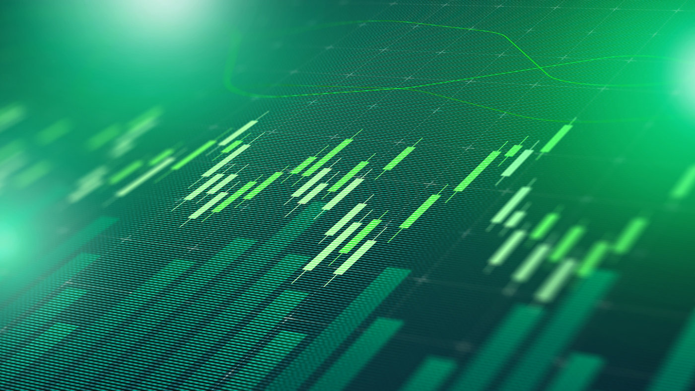 Digital display shows stock market trends with green bars and lines representing data points.