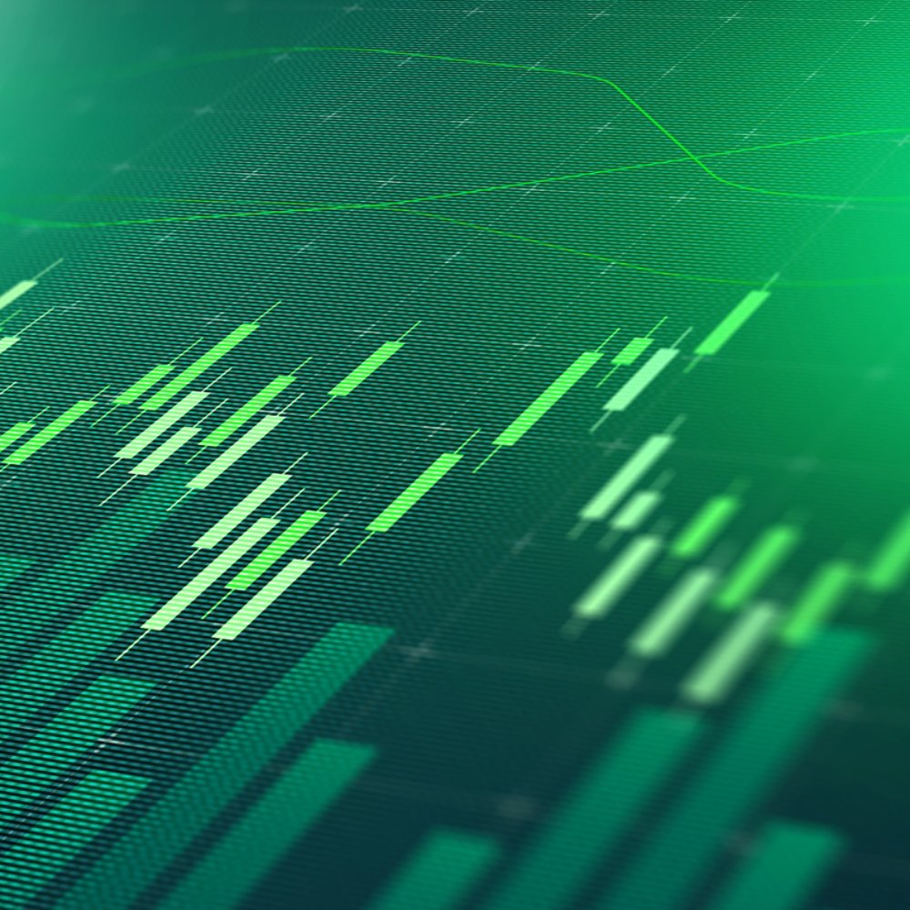 Digital display shows stock market trends with green bars and lines representing data points.