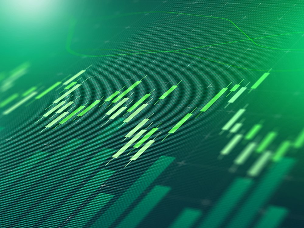 Digital display shows stock market trends with green bars and lines representing data points.