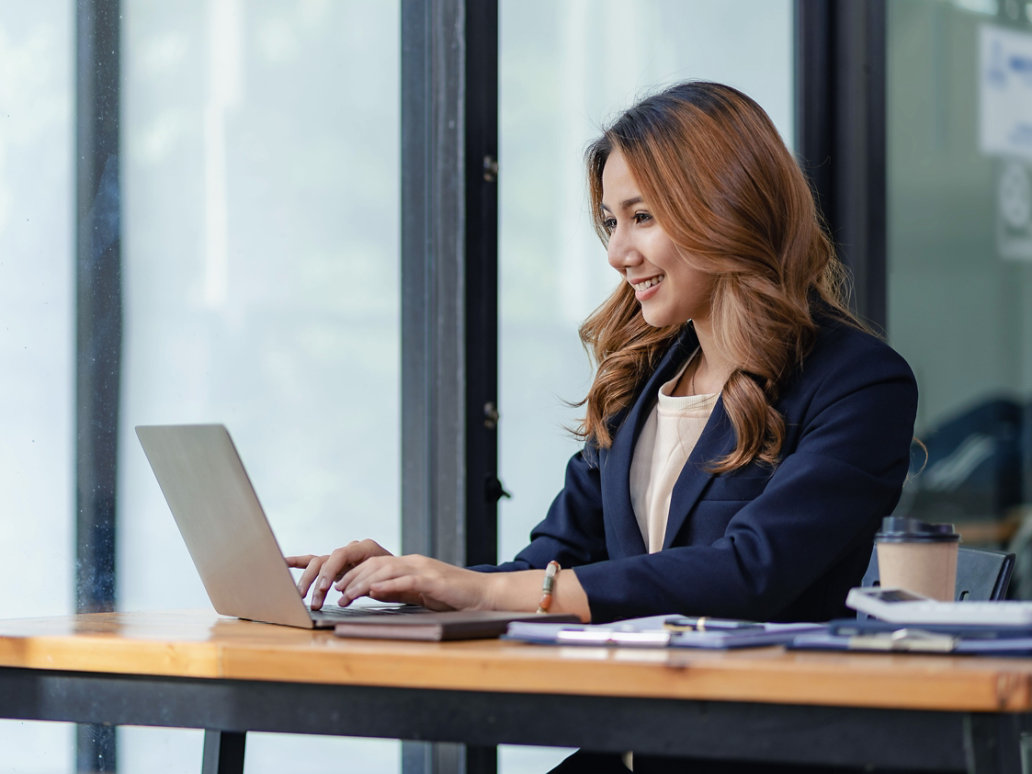 Asian female entrepreneur working in finance at home office analyzing financial graphs on documents with laptop on table in office, Asian female entrepreneur working in finance at home office anal