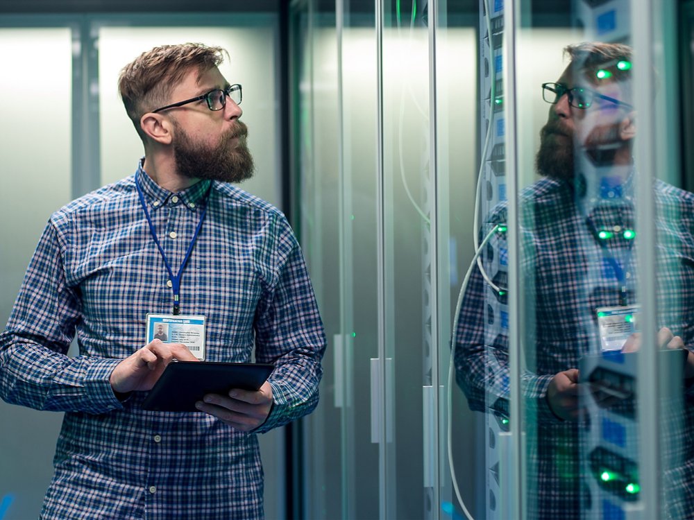 Bearded technician working in server room