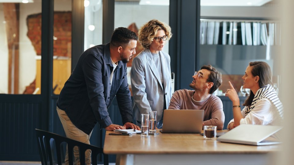 Business people having a meeting in a digital marketing agency. Group of business professionals discussing a project in an office. Teamwork and collaboration in a creative workplace.