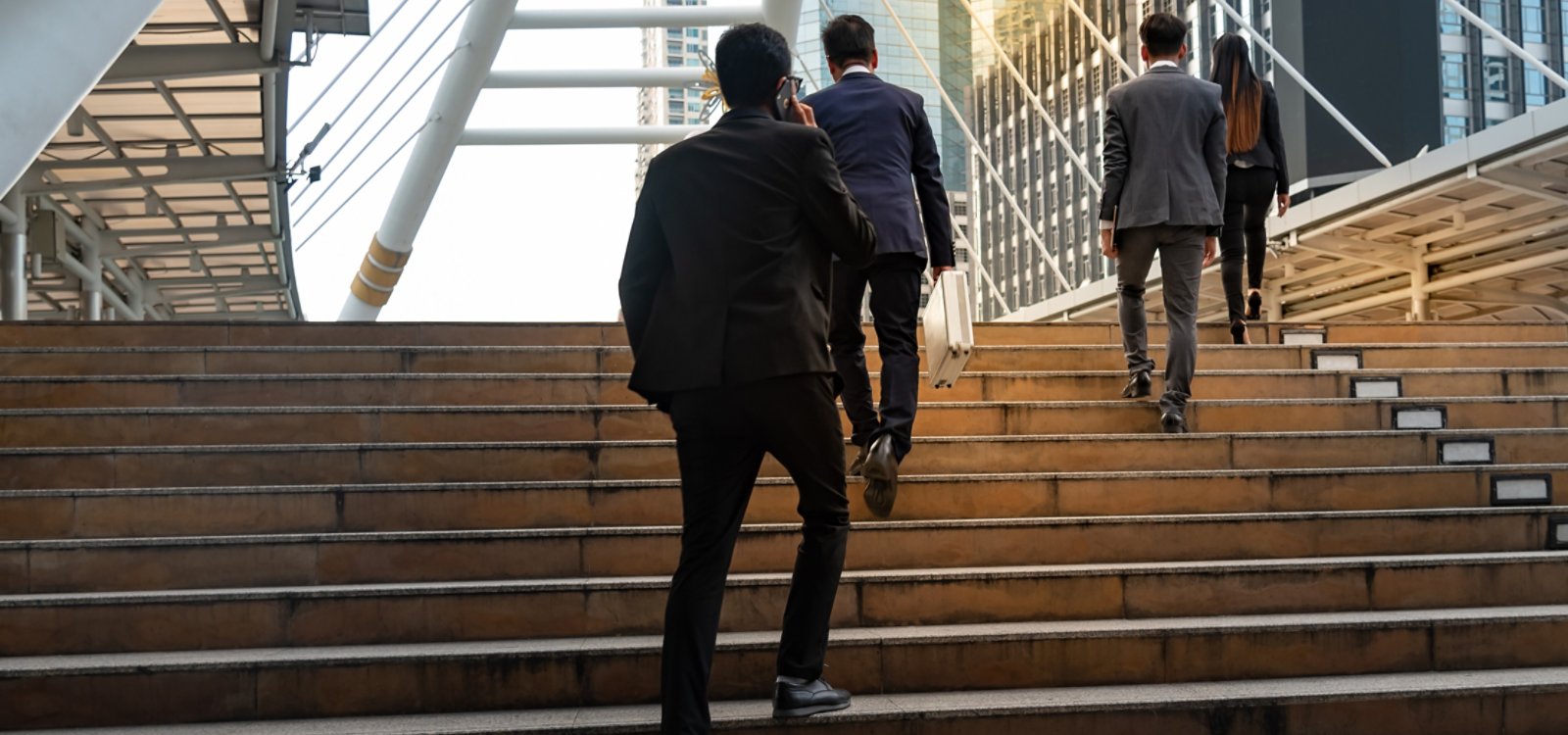 Businessmen team, group Walking up the stairs in the downtown area Full of tall buildings, to business concept.