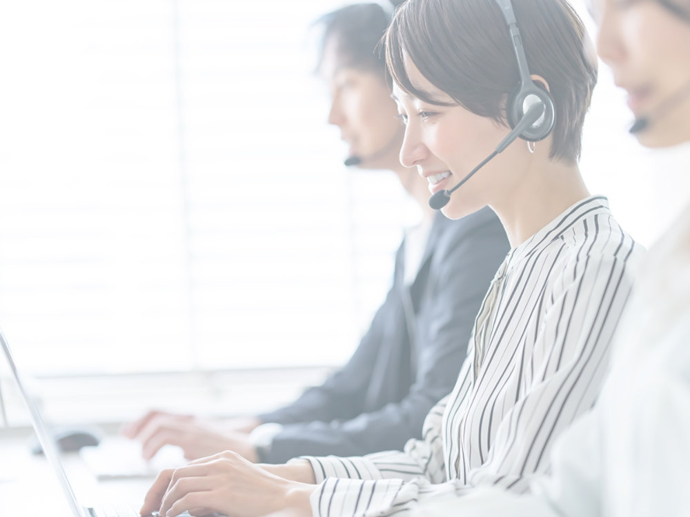 Team of people working at a call center with headsets on