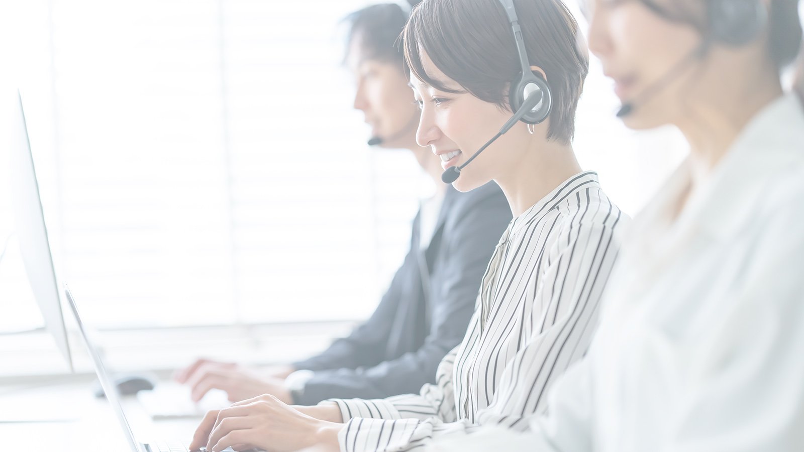 Team of people working at a call center with headsets on