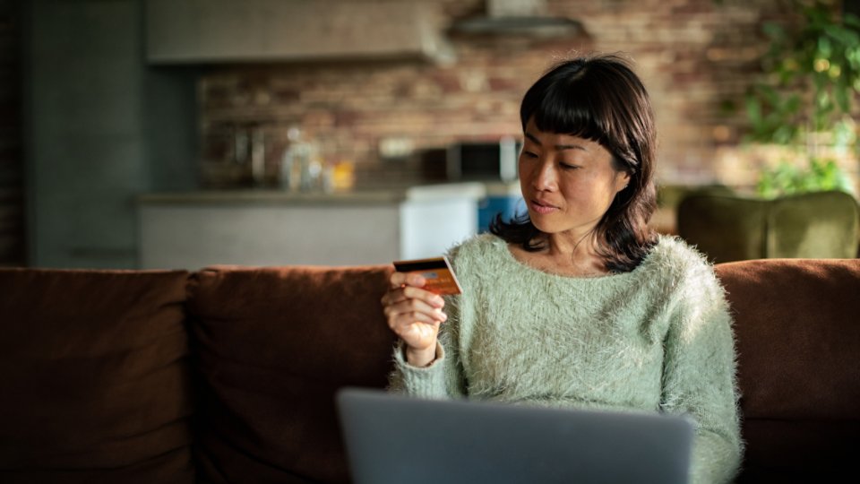 Woman shopping online at home with credit card