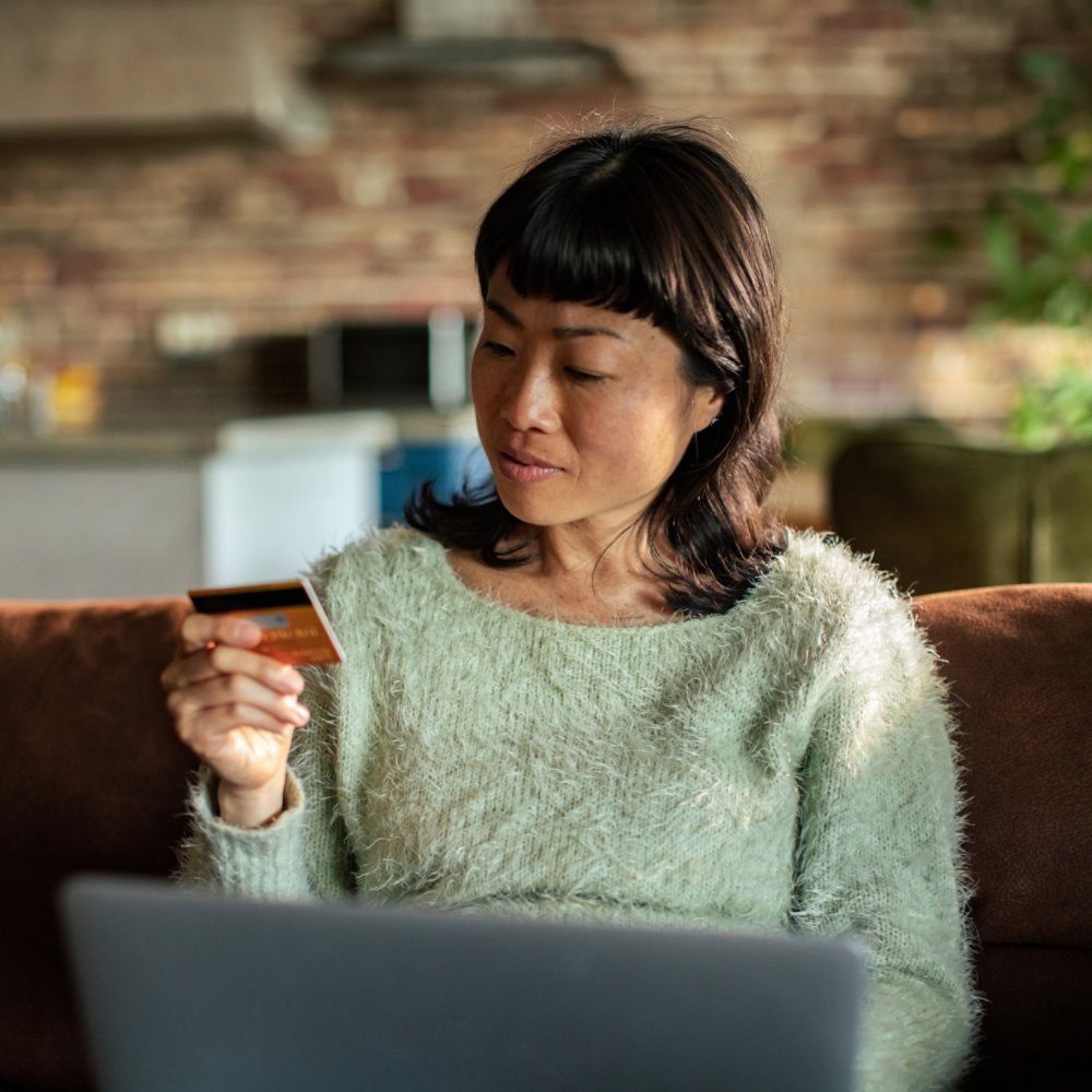 Woman shopping online at home with credit card