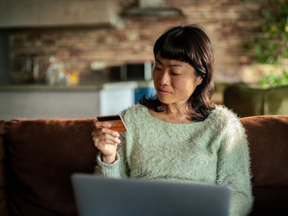 Woman shopping online at home with credit card