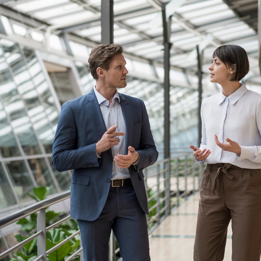 Businessman and woman talking in sustainable office building