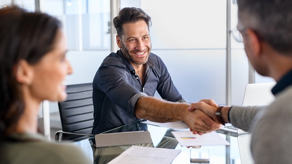Businessman handshake with couple during meeting to protect their investments. Handshake of a manager with mature couple after agreement for financial investment. Happy financial advisor shaking hands with his client after insurance deal.