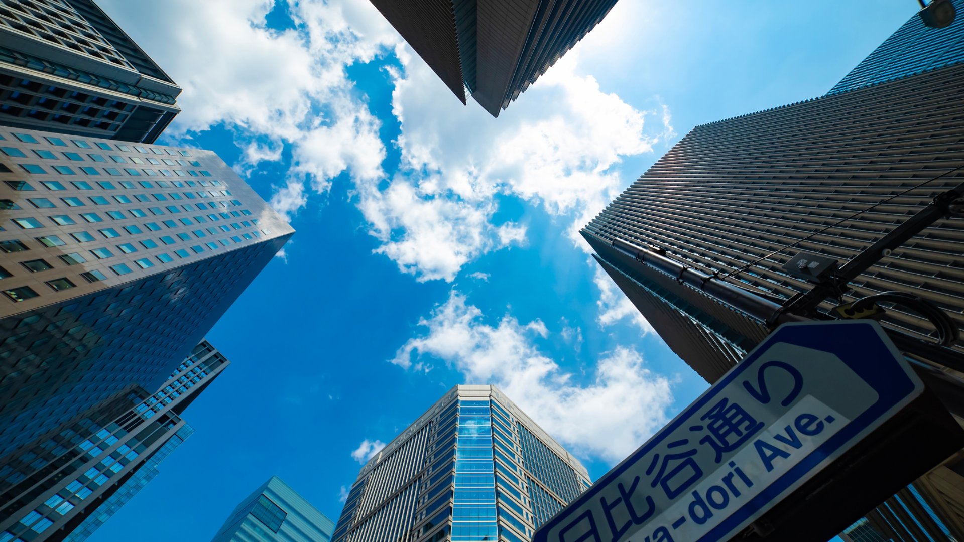 A cityscape of cloud reflecting the office building low angle view. High quality photo. Chiyoda district Otemachi Tokyo Japan 08.26.2025 It is center of the city in Tokyo. Translation on board text avenue name.