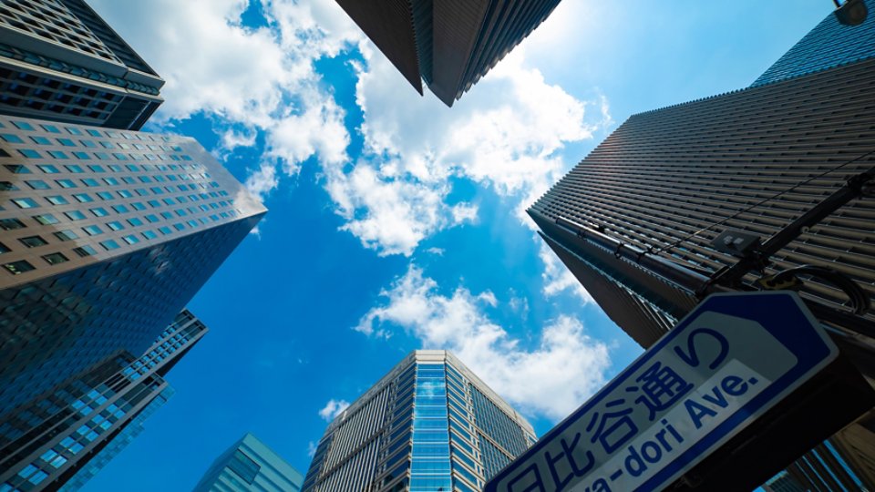 A cityscape of cloud reflecting the office building low angle view. High quality photo. Chiyoda district Otemachi Tokyo Japan 08.26.2025 It is center of the city in Tokyo. Translation on board text avenue name.