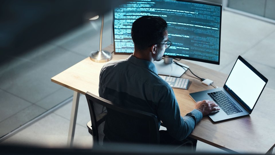 Man, programmer and coding at night on laptop mockup screen for networking, malware or software at the office. Male person, coder or developer working late in computer display in problem solving.