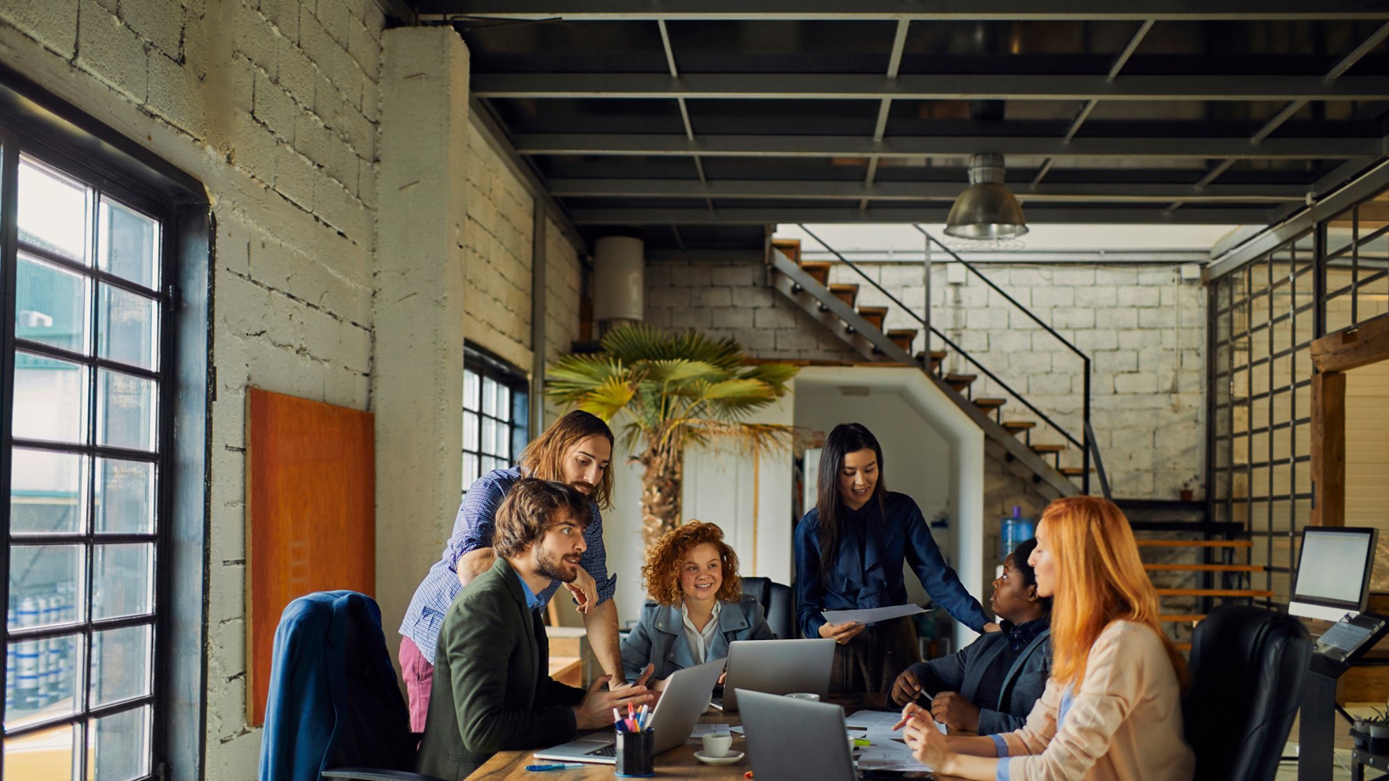 Young and diverse group of designers having a meeting in an office while working in a startup company