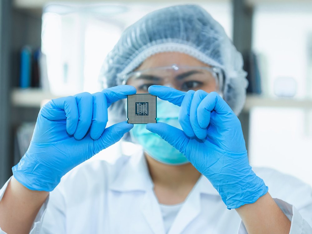 Portrait of computer engineer is holding CPU's computer for examination.