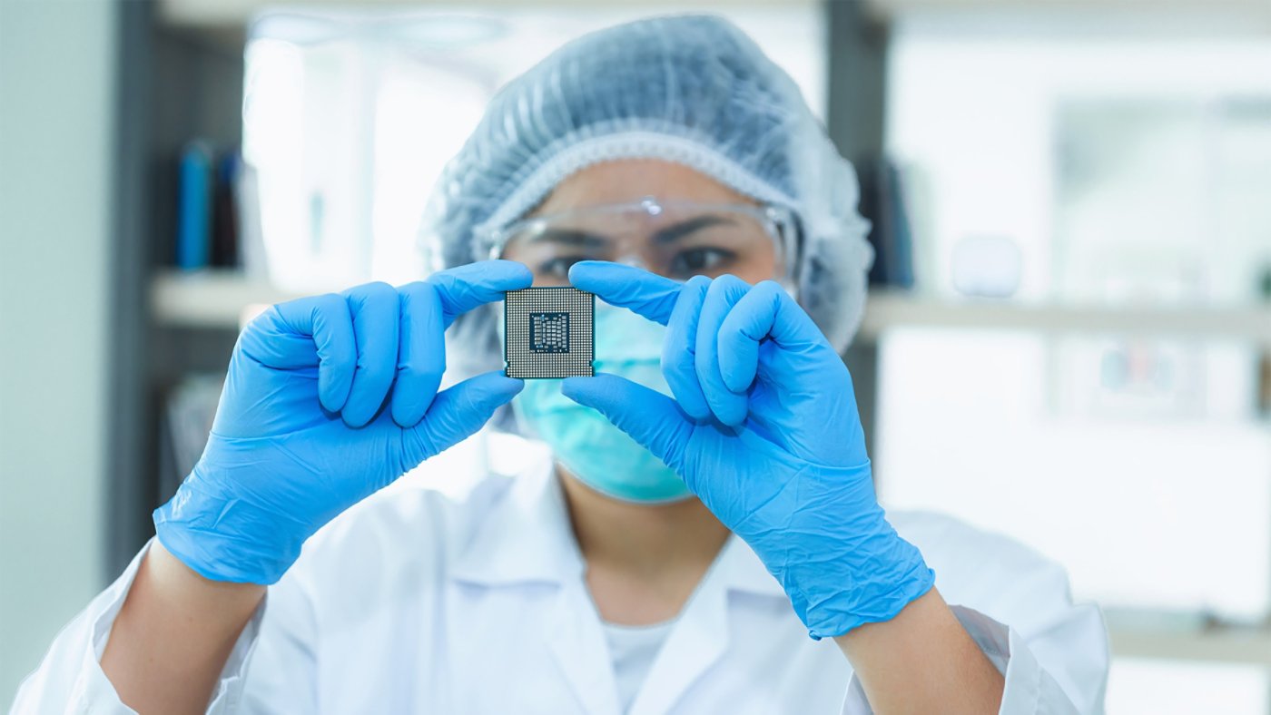 Portrait of computer engineer is holding CPU's computer for examination.