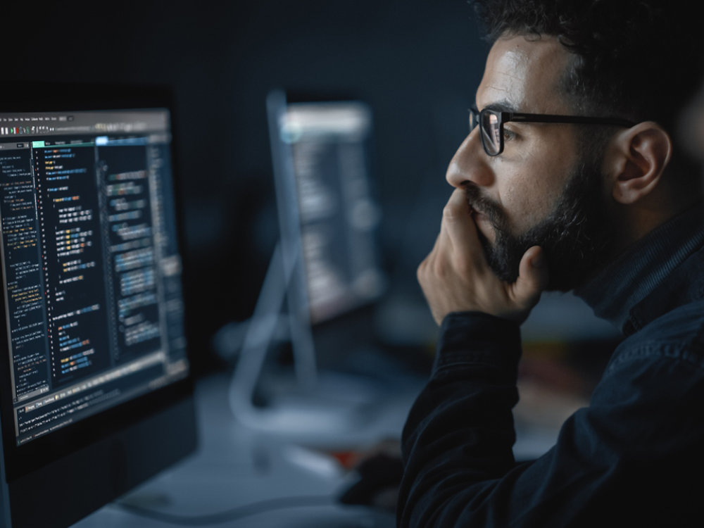 Handsome Smart Male Student, Studying in University with Diverse Multiethnic Classmates. He Works on Desktop Computer in College. Applying His Knowledge in Writing Code, Developing Software.