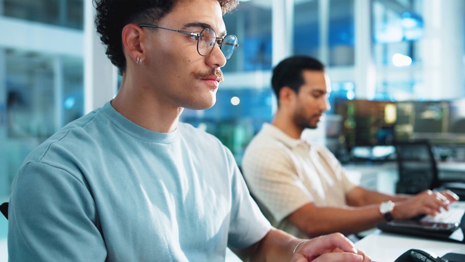 A group of four colleagues standing in an elegant modern office discussing a green energy project