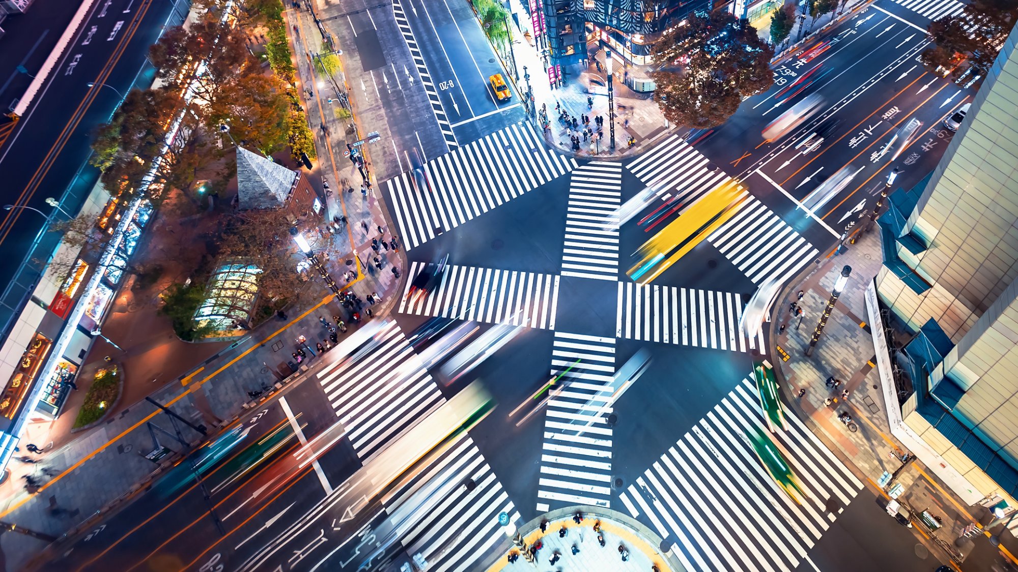 Traffic and people cross a busy intersection in Ginza, Tokyo