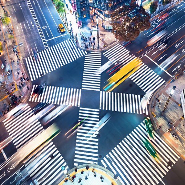 Traffic and people cross a busy intersection in Ginza, Tokyo