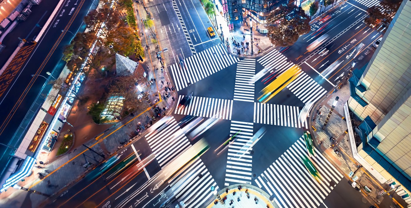 Traffic and people cross a busy intersection in Ginza, Tokyo