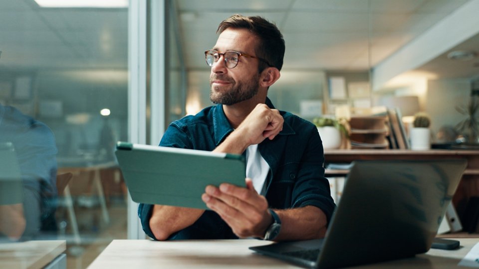 Tablet, thinking and smile with business man in office for planning, ui designer and app review. Developer solutions, reflection and research with person in agency for project idea and startup.