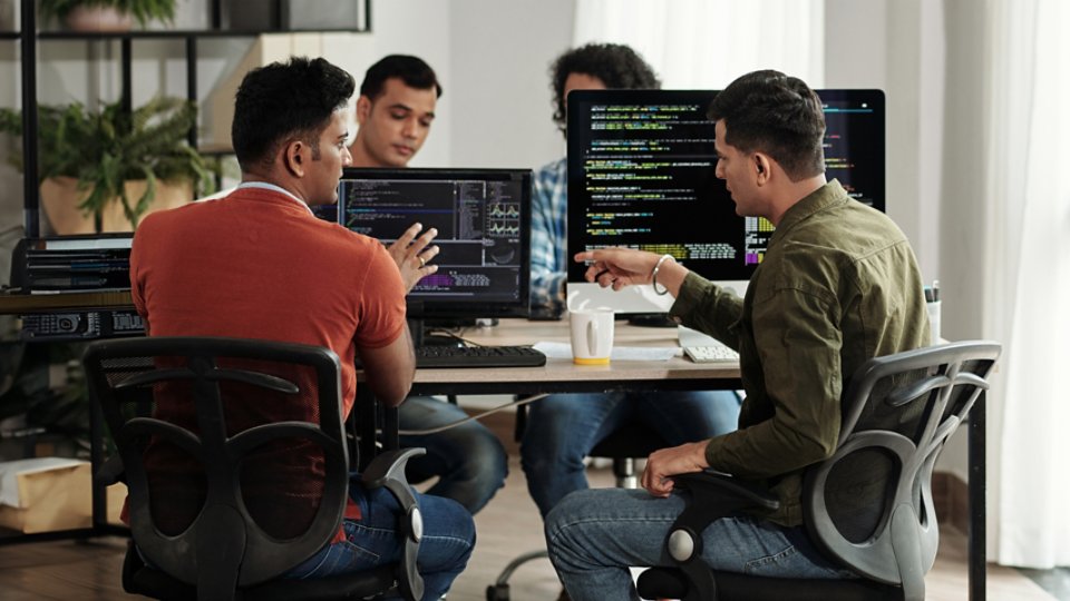 4 developers working together in living room on workstations