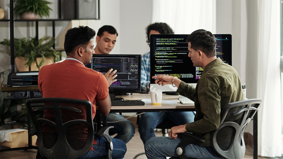 developers having a discussion un living room with workstations 