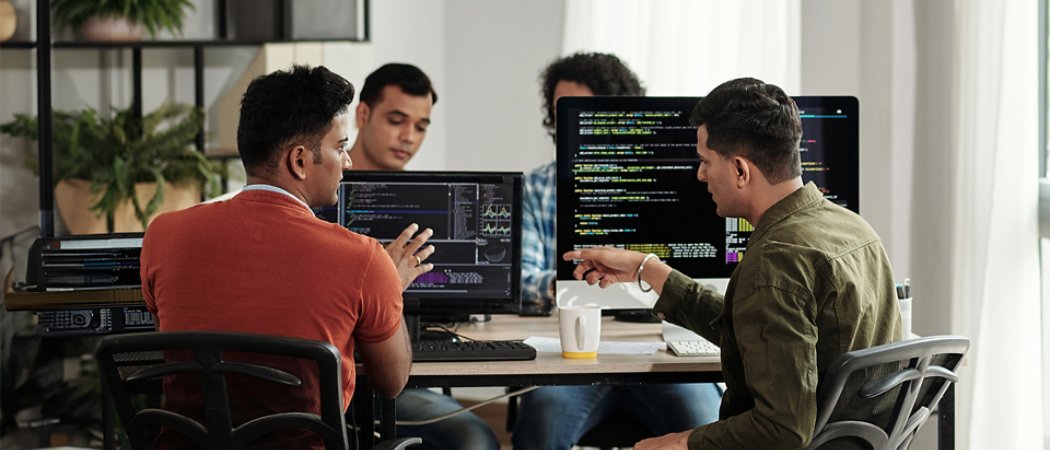 developers having a discussion un living room with workstations 