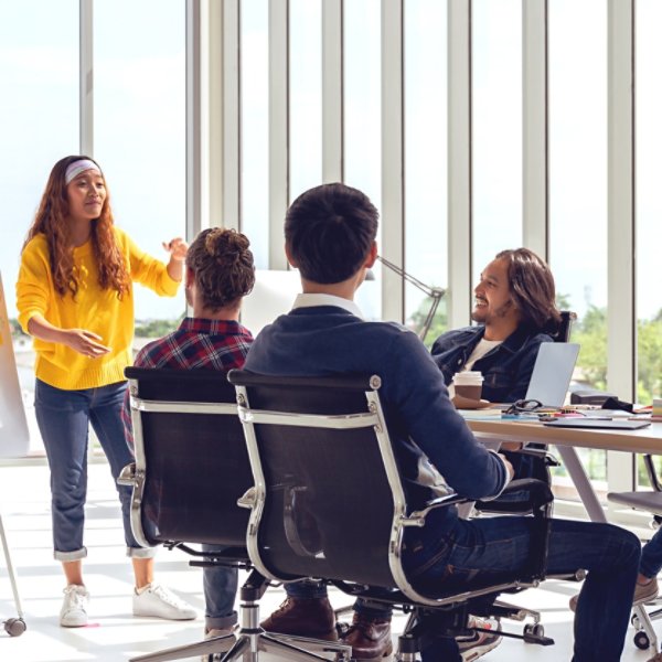 Young asian creative hipster female leader standing and making presentation at modern office happy talking and brainstorming idea with teamwork. Casual asian people business meeting workshop concept.