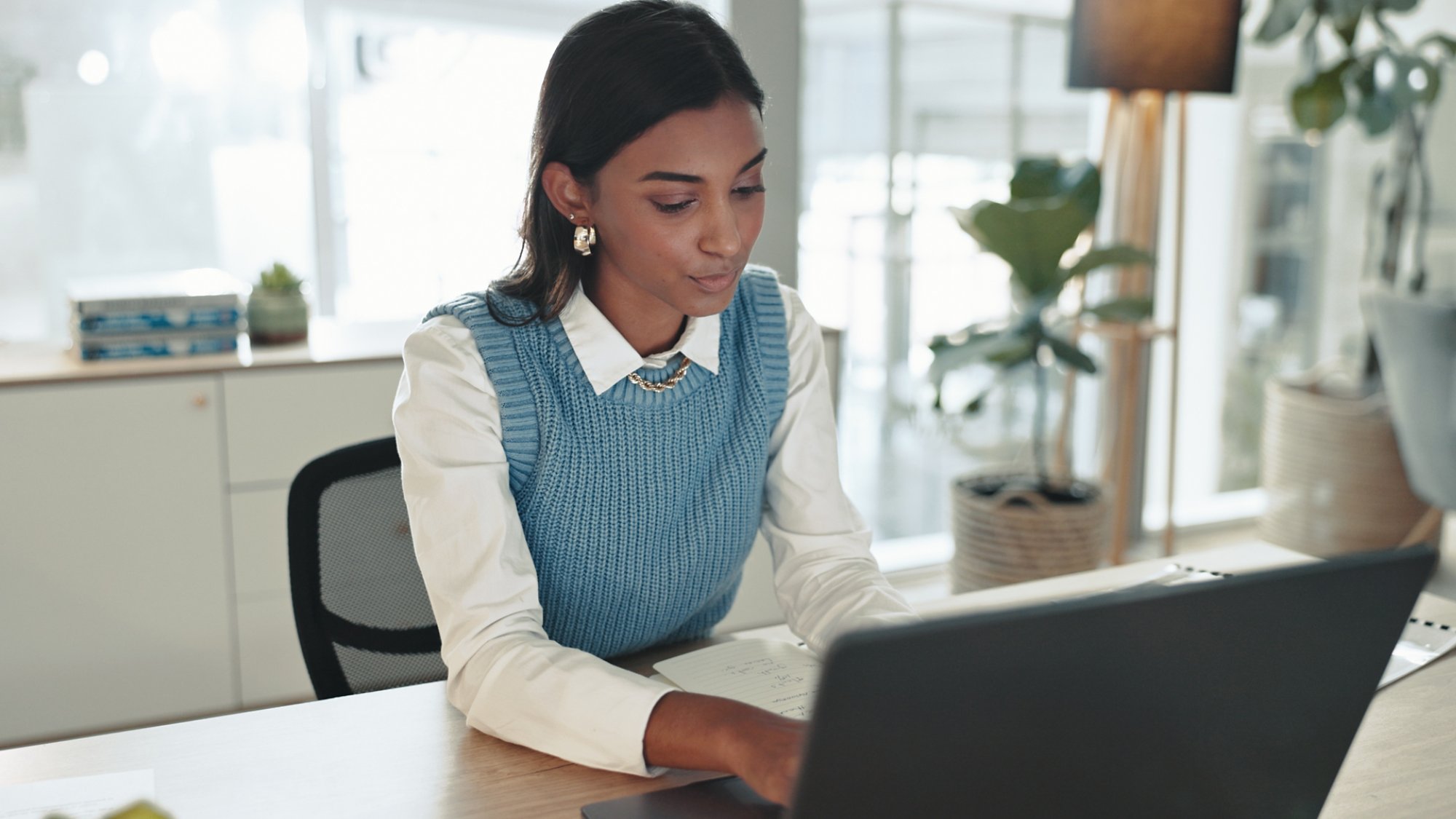 Accounting, finance and laptop with business Indian woman at desk in office for bookkeeping report. Computer, research and typing with professional accountant in workplace for financial management.