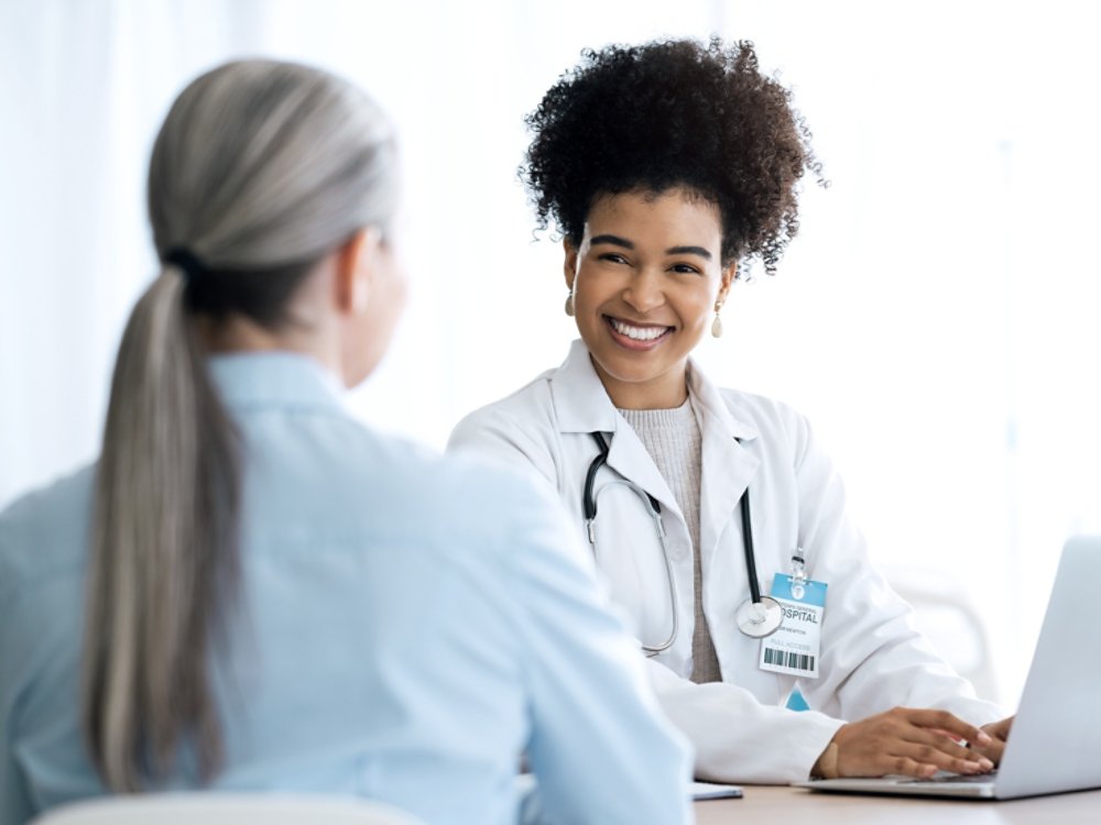 Doctor, woman and laptop for healthcare support, hospital services and patient history, charts or results in office. Medical professional and client on computer for consultation information or advice.