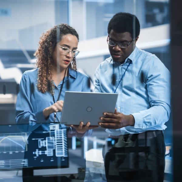 Multiethnic Robotics Engineer Talking to Project Manager, Discussing Robot Dog Concept in High Tech Research and Development Facility. Professional Industrial Scientists Working in the Background.