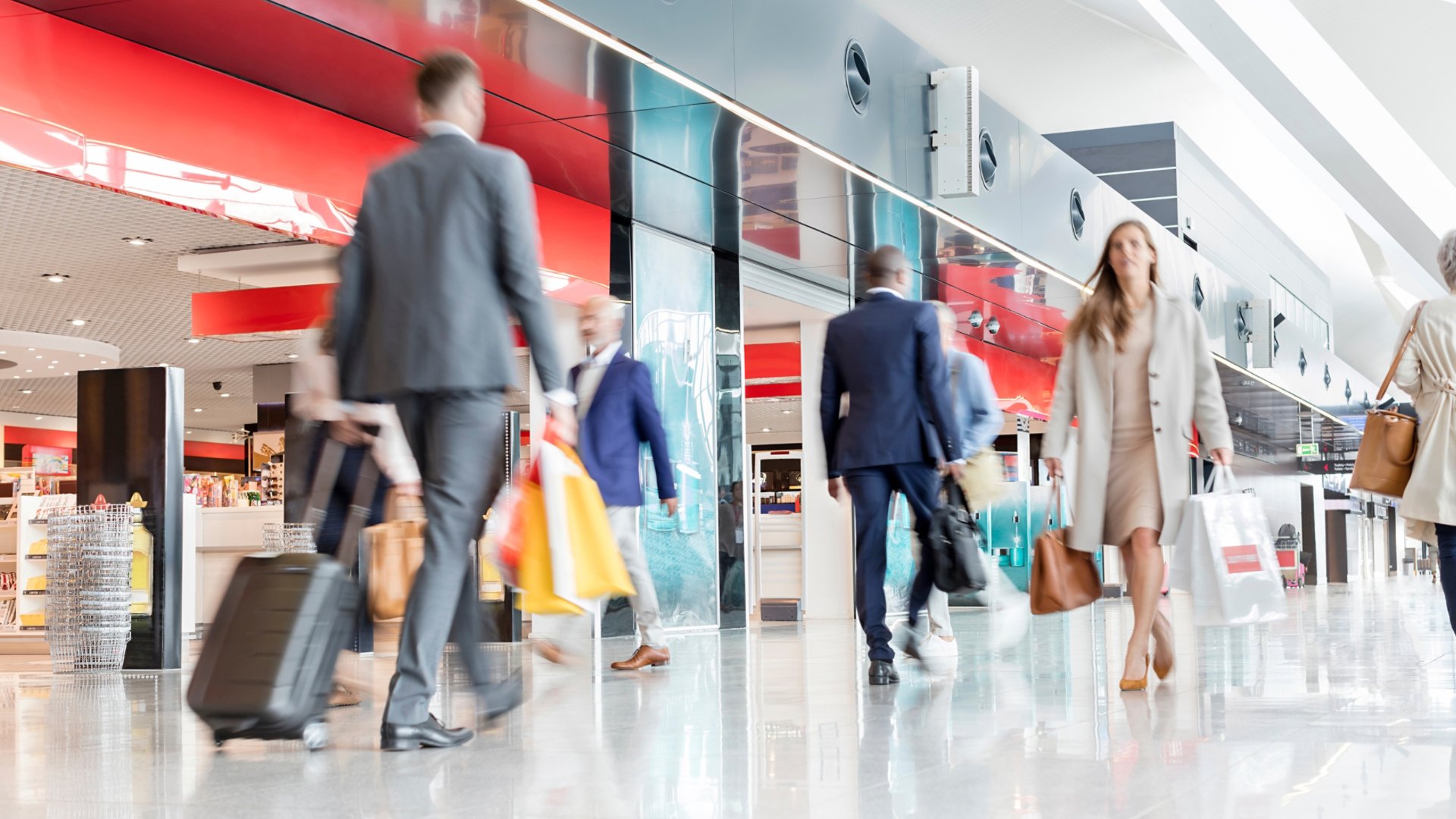 Travelers walking in airport concourse