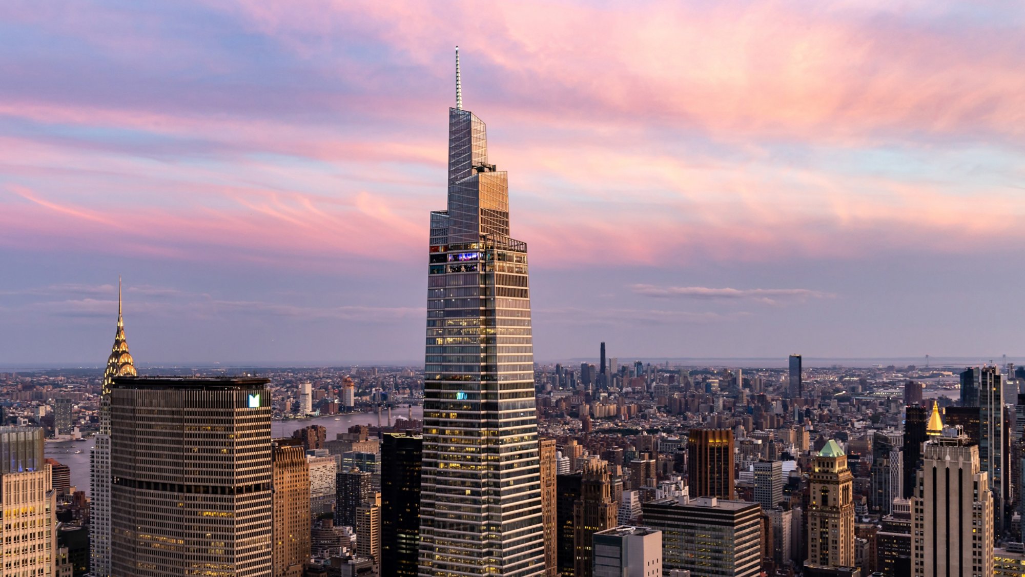 Aerial View of One Vanderbilt Met Life Building NYC Skyline with pink skies and clouds.