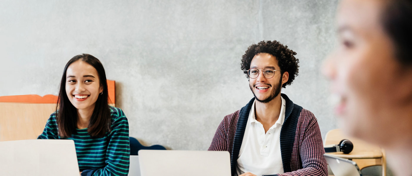 A group of students smiling and enjoying listening to tutor during a university seminar.