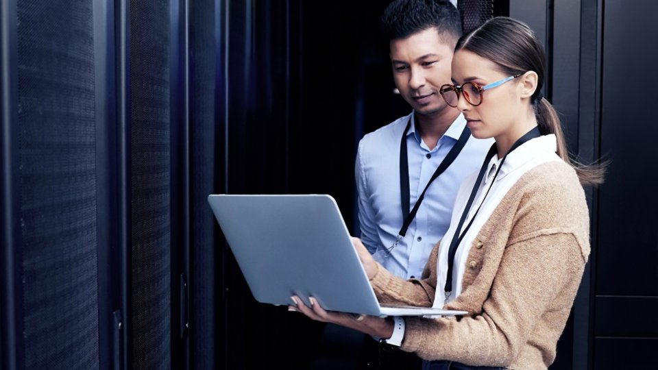 Shot of two technicians working together in a server room.