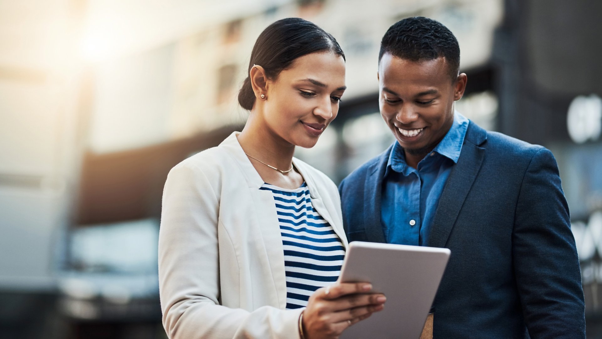 Shot of two businesspeople using a digital tablet in the city.