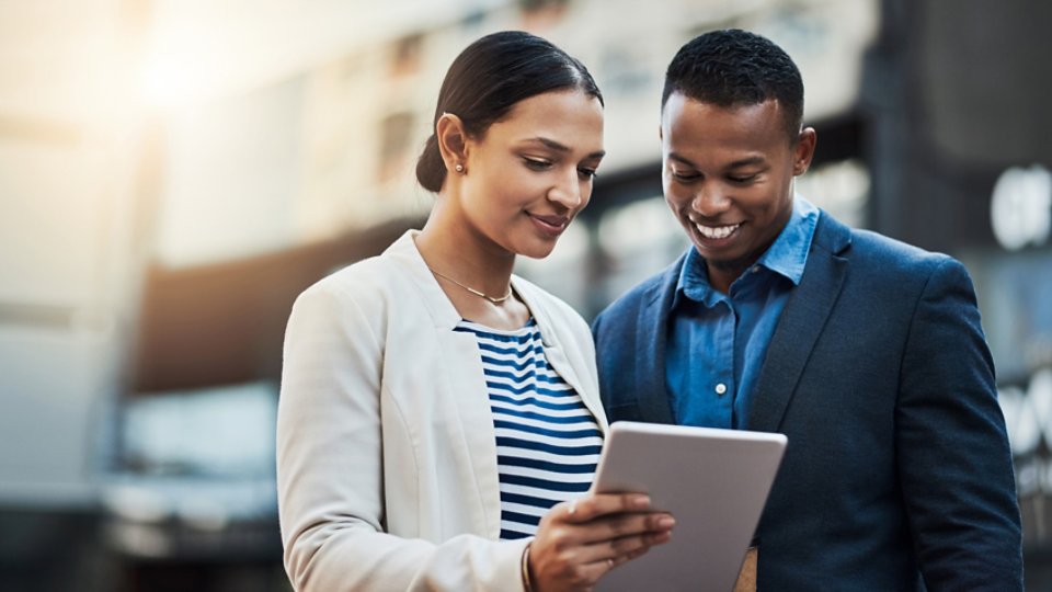 Shot of two businesspeople using a digital tablet in the city.