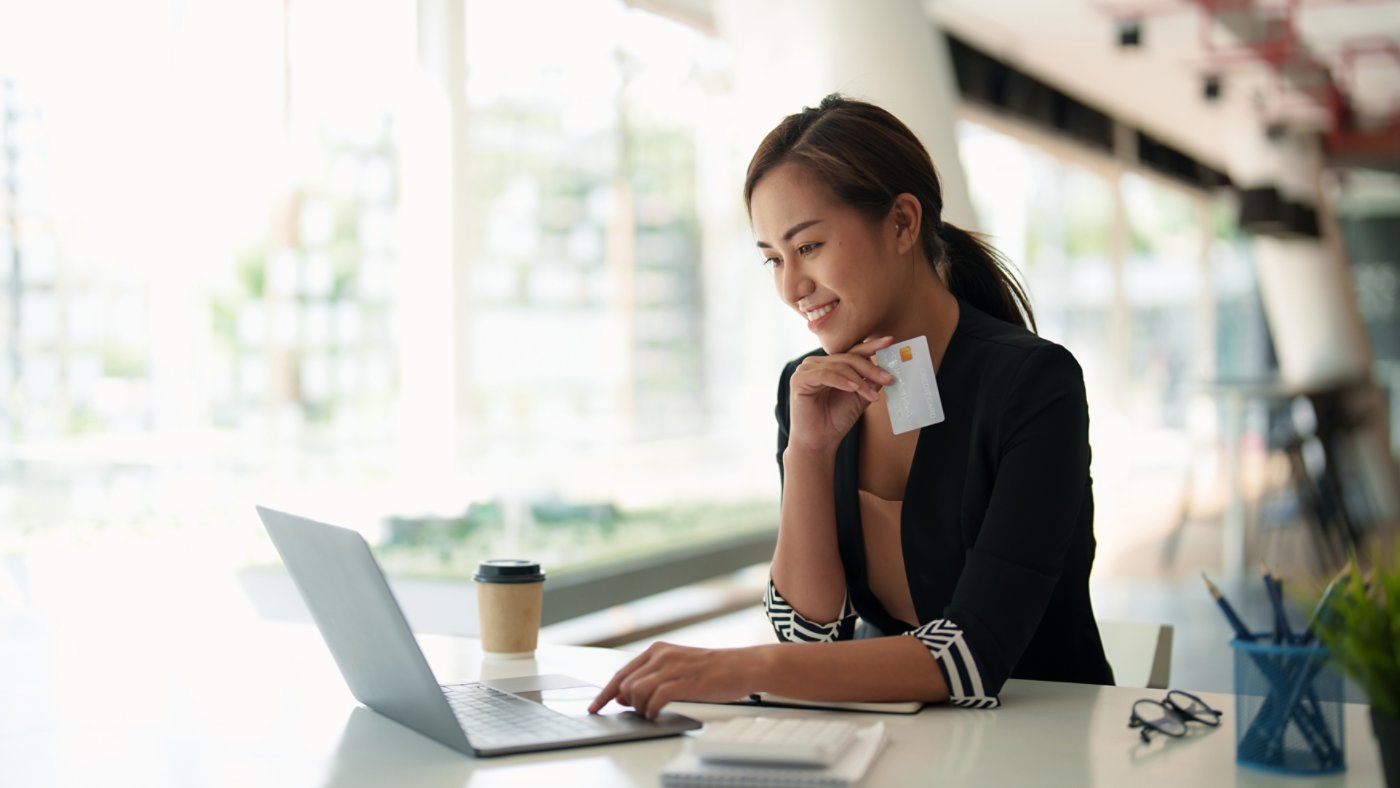 Close up of black girl hold bank credit card and type on laptop, shopping online using computer, buying goods or ordering online, entering bank accounts and details in online banking offer.