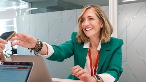 Female Kyndryl employee loans her phone to a coworker to view info relevant to a project