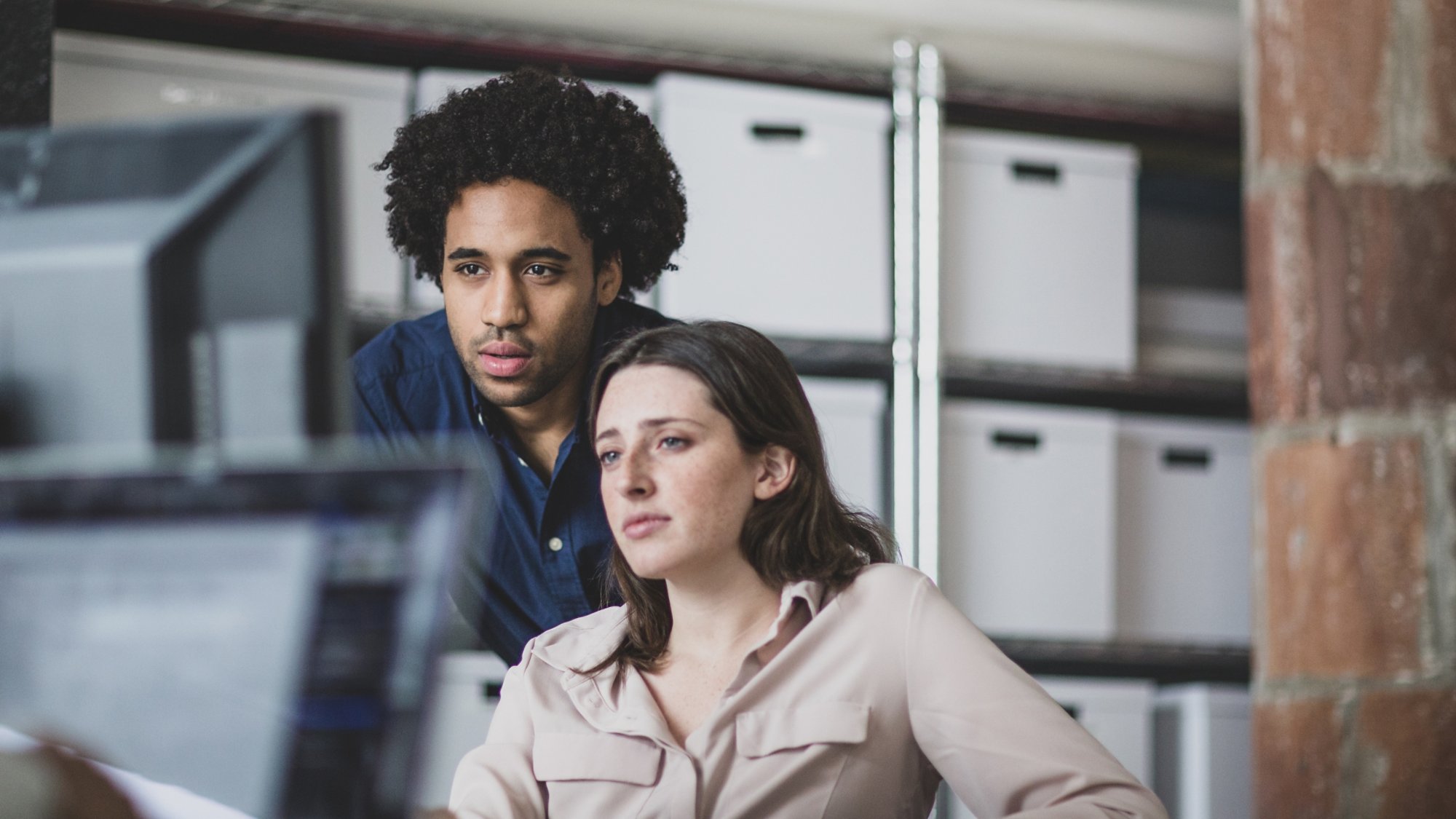 Coworkers looking at a desktop computer together