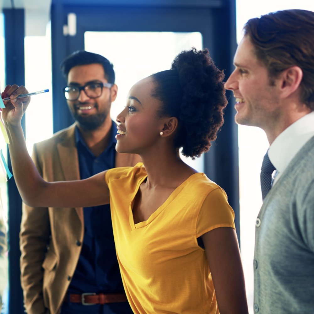 Cropped shot of a group of businesspeople brainstorming with notes on a glass wall in an office.