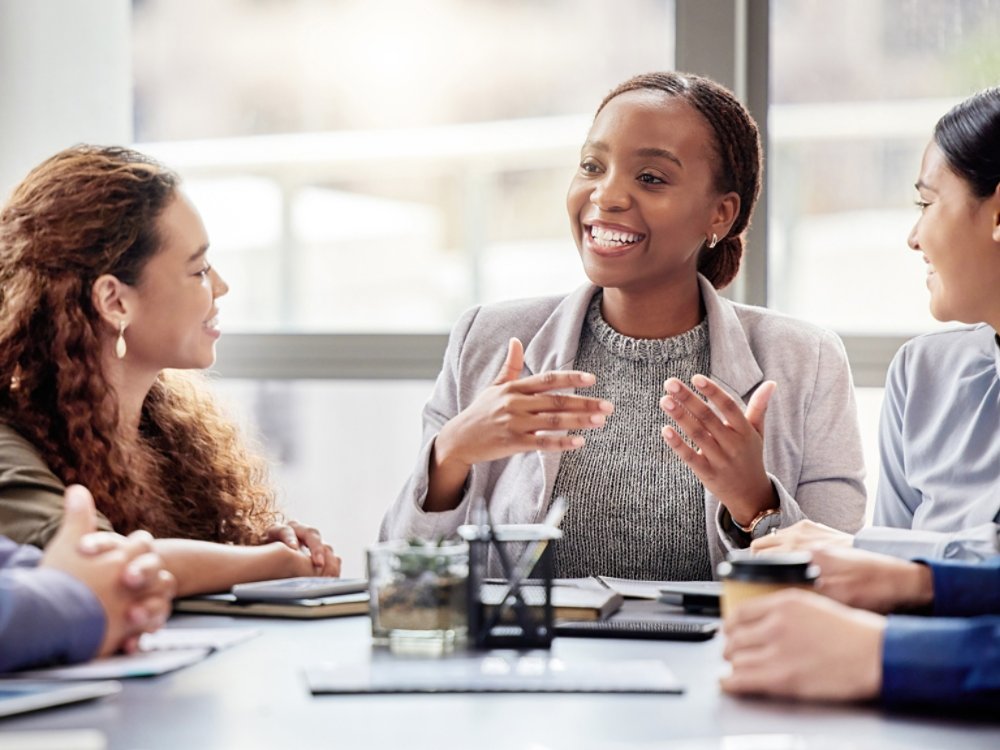 Discussion, meeting and business people in office for teamwork, planning or review at table. Collaboration, professional and group of diverse employees for ideas, conversation or project development.