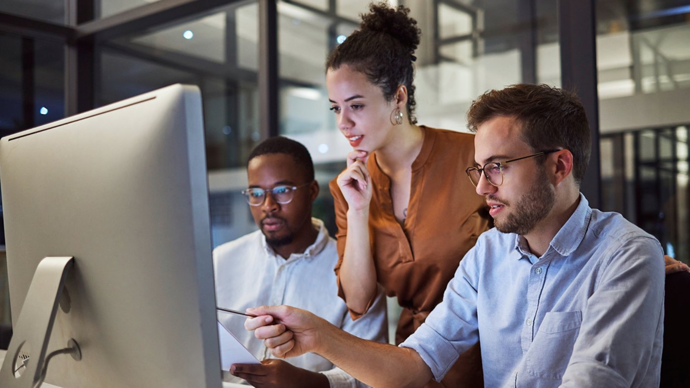 Group working around computer screen 