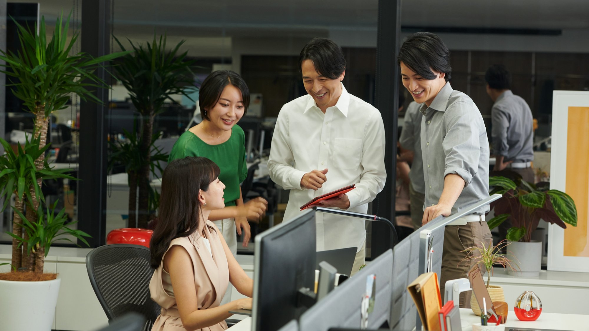 Group of people around a computer in an office