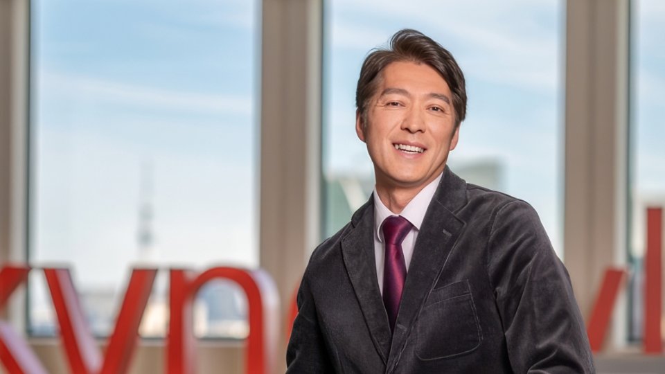 Male Kyndryl employee from Japan sitting in front of Kyndryl signage