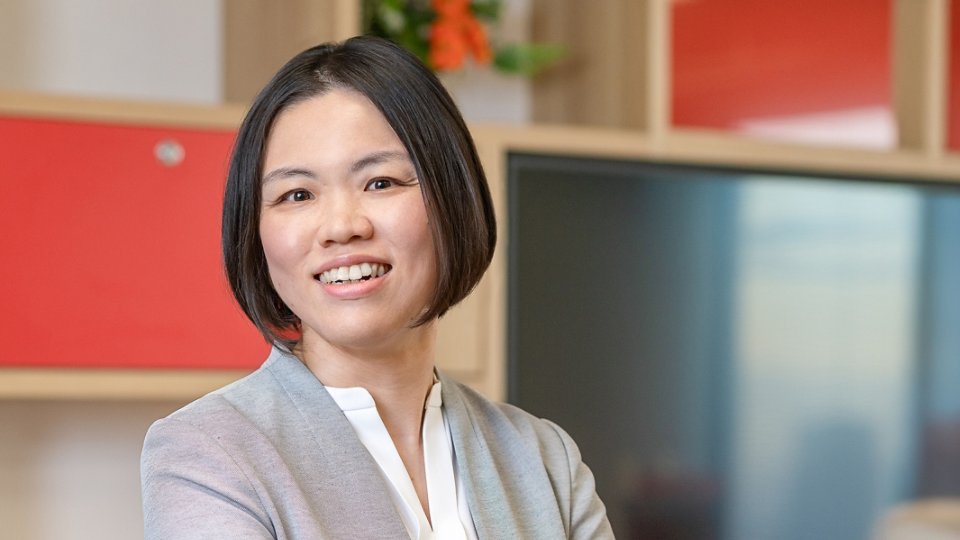 Female Kyndryl employee from Japan standing in the office
