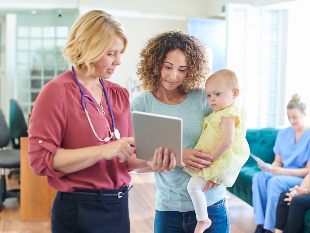 female patient with child chats to the doctor