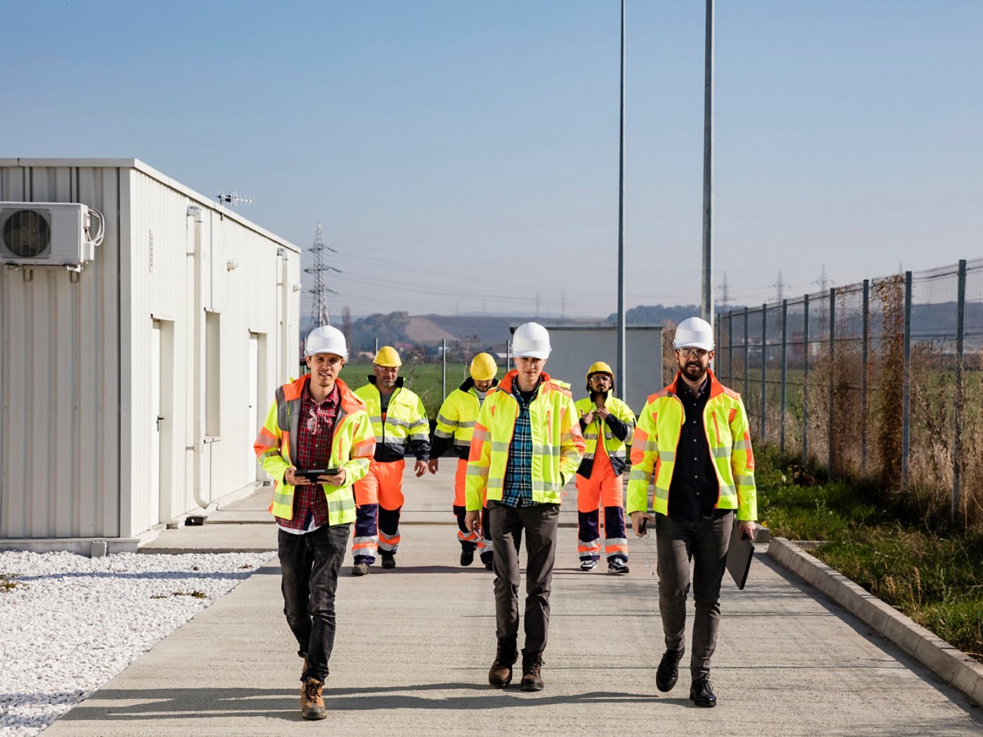 Engineers and workers walking down industrial plant